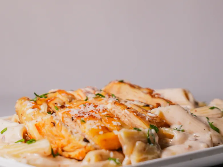 Grilled chicken over creamy penne with parmesan
